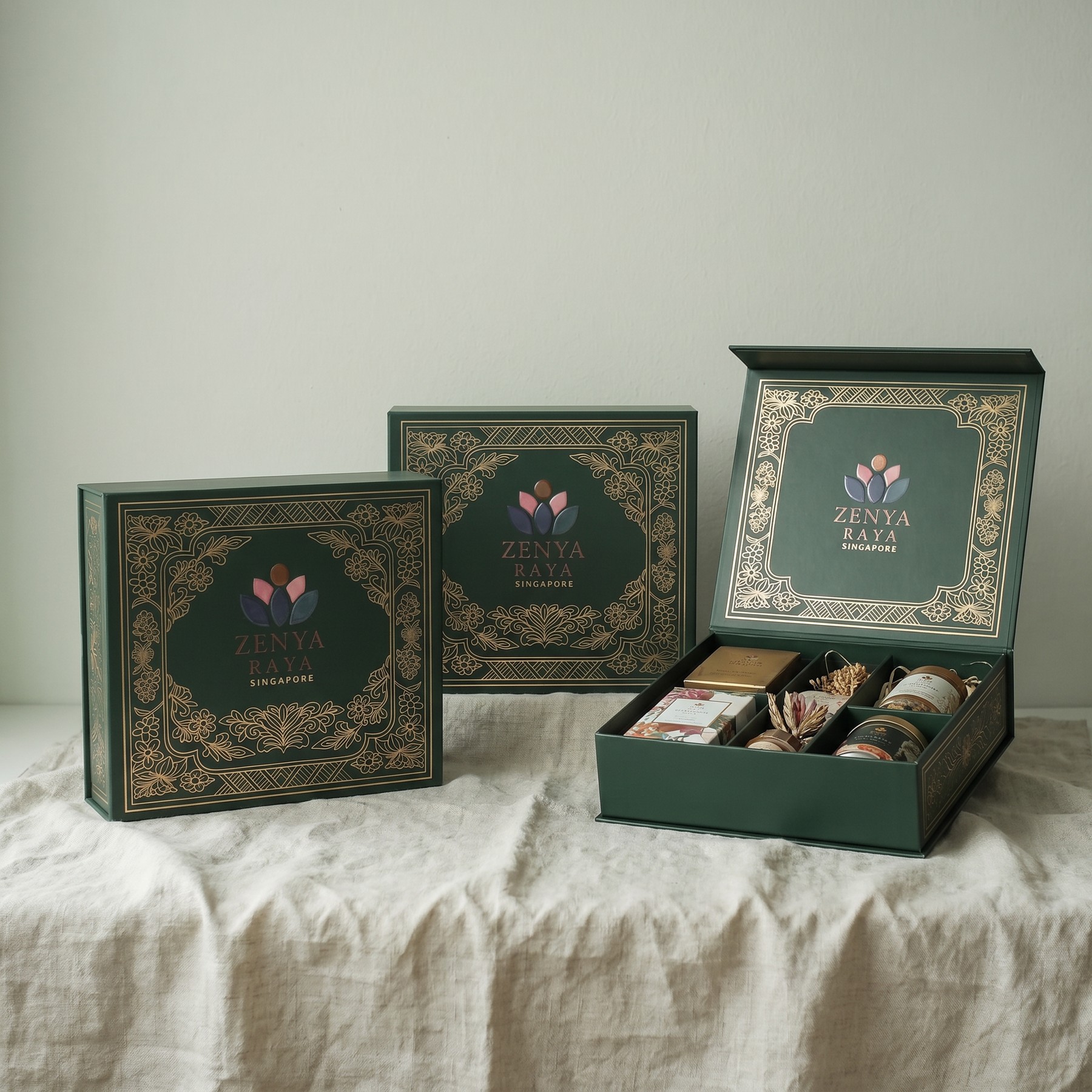 Zenya Raya deep-green and gold boxes, shown closed and open